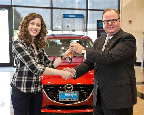 Mazda North American Operations President and CEO, Jim O'Sullivan, presents the keys to an all-new 2014 Mazda3 to Lauren Carter, who purchased the 10-millionth Mazda sold in the US at Continental Mazda in Naperville, Ill. on October 21, 2013.