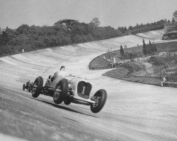 John Cobb in the 24 litre Napier-Railton taking the ‘bump’ on the Members’ Banking while setting the Brooklands track record i